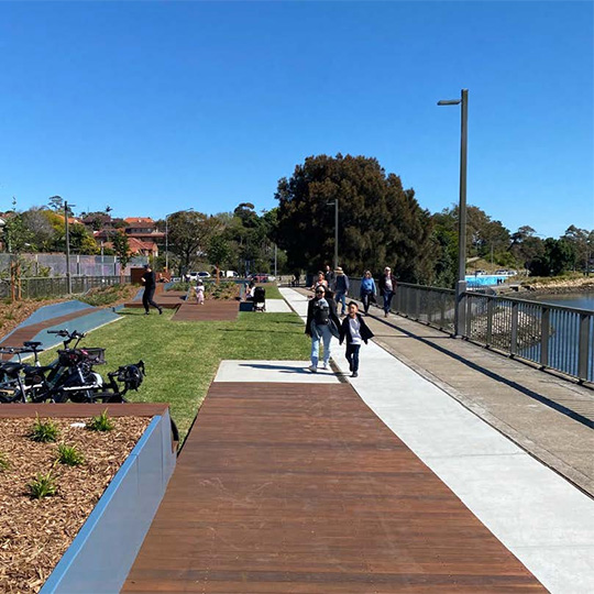 A bridge over a body of water. The bridge includes shared use paths and landscaped areas.